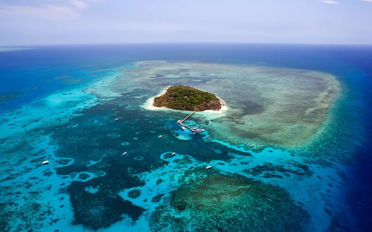A small coral island surrounded by turquoise water off the Cairns coast