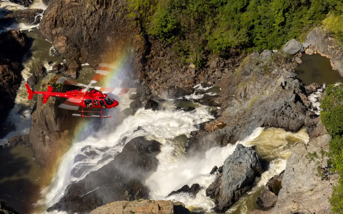 A helicopter over rainforest and a waterfall near Cairns