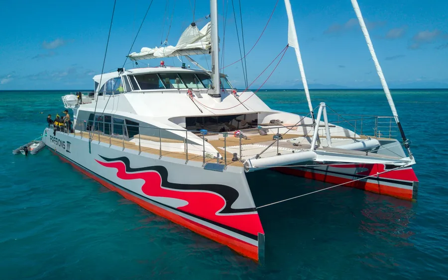 A premium catamaran anchored on the turquoise outer reef