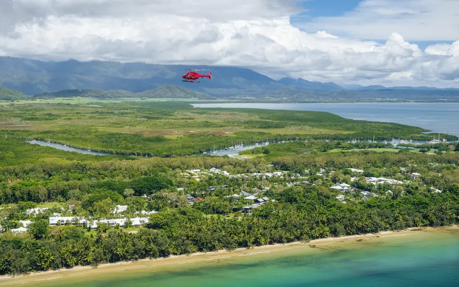 A helicopter over the coastline and beaches at Port Douglas